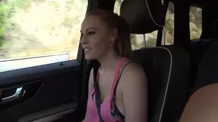 A stunning young lady indulges in the exhilaration of riding a man's erect member in a car, showcasing her mesmerizing figure and alluring ginger charm