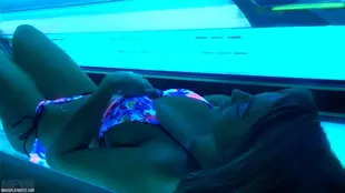 A fair-skinned woman enjoys the indoor tanning experience